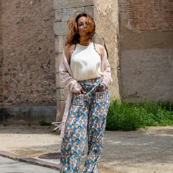 Pantalón largo estampado. Bolsillos con detalles metálicos bordados. Anudado en el delantero y goma en la parte trasera. Bajo con volante. GF.SEMCHAI-000008